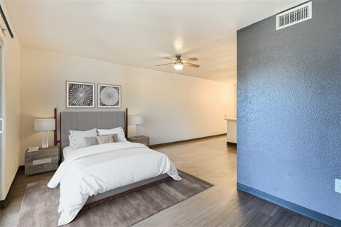 A bedroom with a large bed and a ceiling fan.