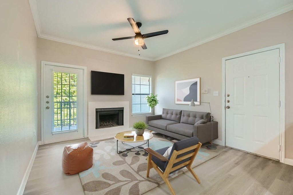 A living room with a grey couch, a coffee table, and a ceiling fan.