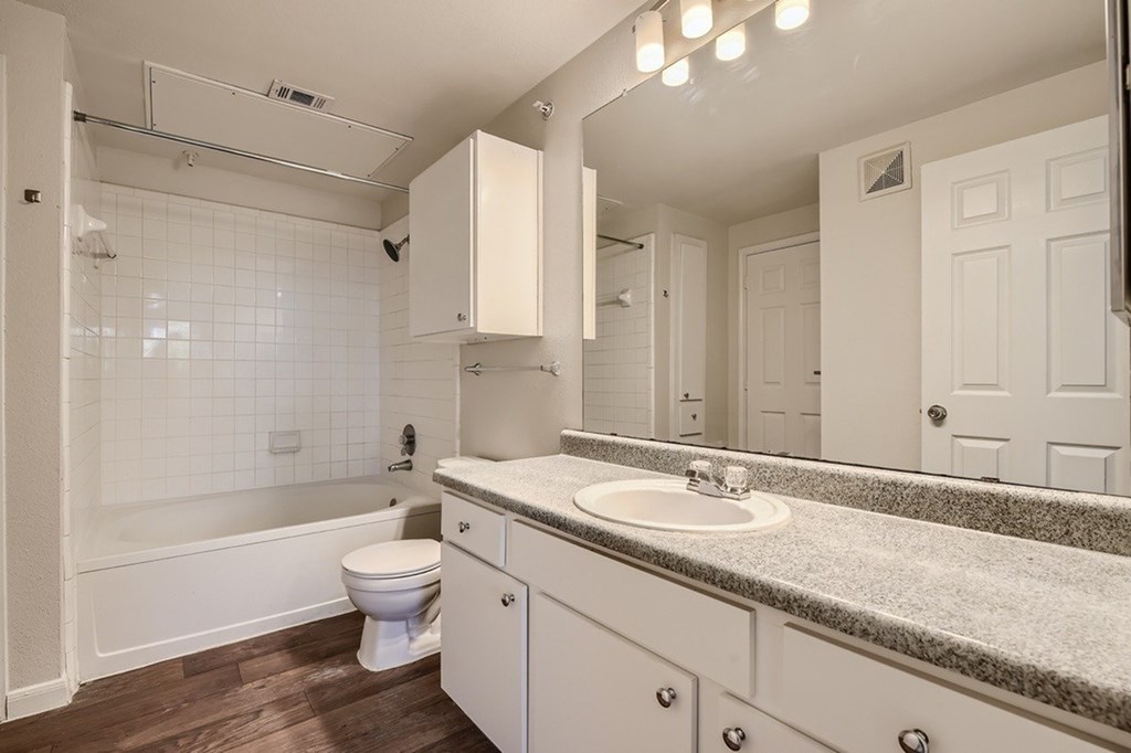 A white bathroom with a toilet, sink, and tub.
