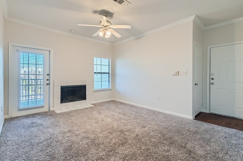 A room with a fireplace and a ceiling fan.