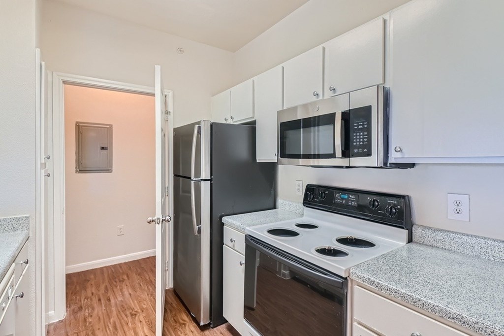 A kitchen with black appliances and white cabinets.