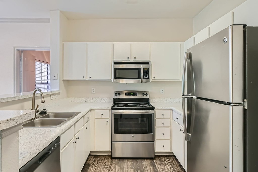 A kitchen with white cabinets and stainless steel appliances.