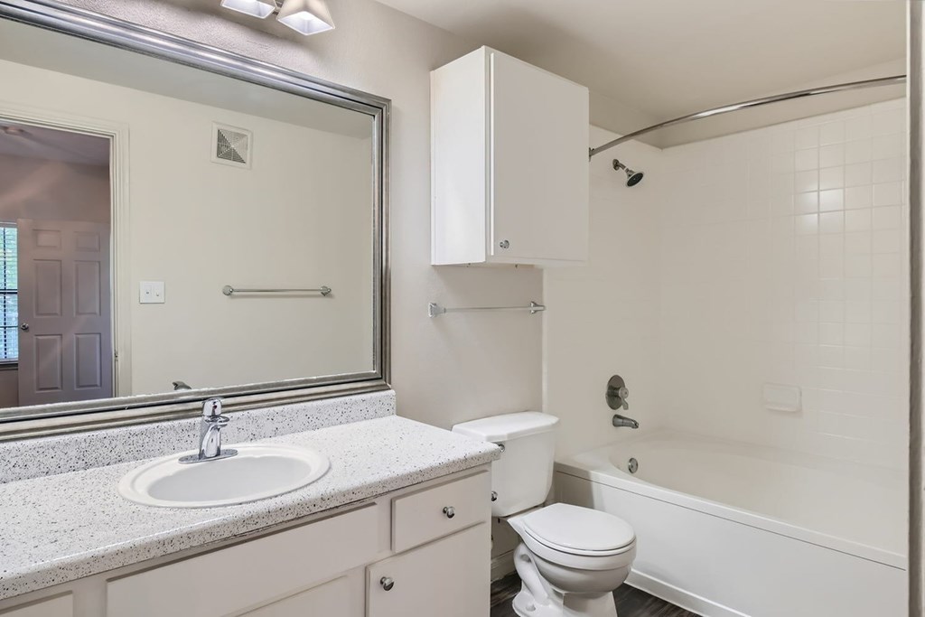 A white bathroom with a sink, toilet, and bathtub.