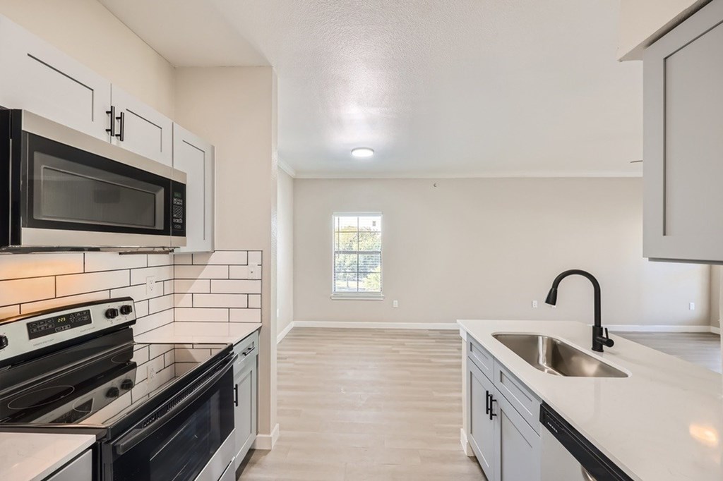 A kitchen with black and white appliances and a white countertop.