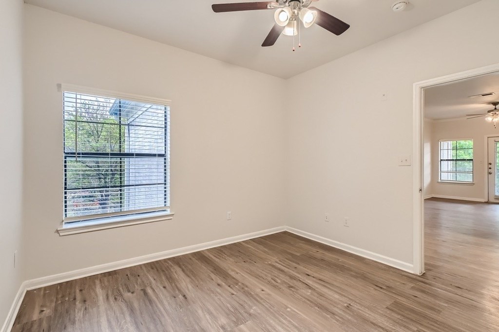 A room with a window and a ceiling fan.