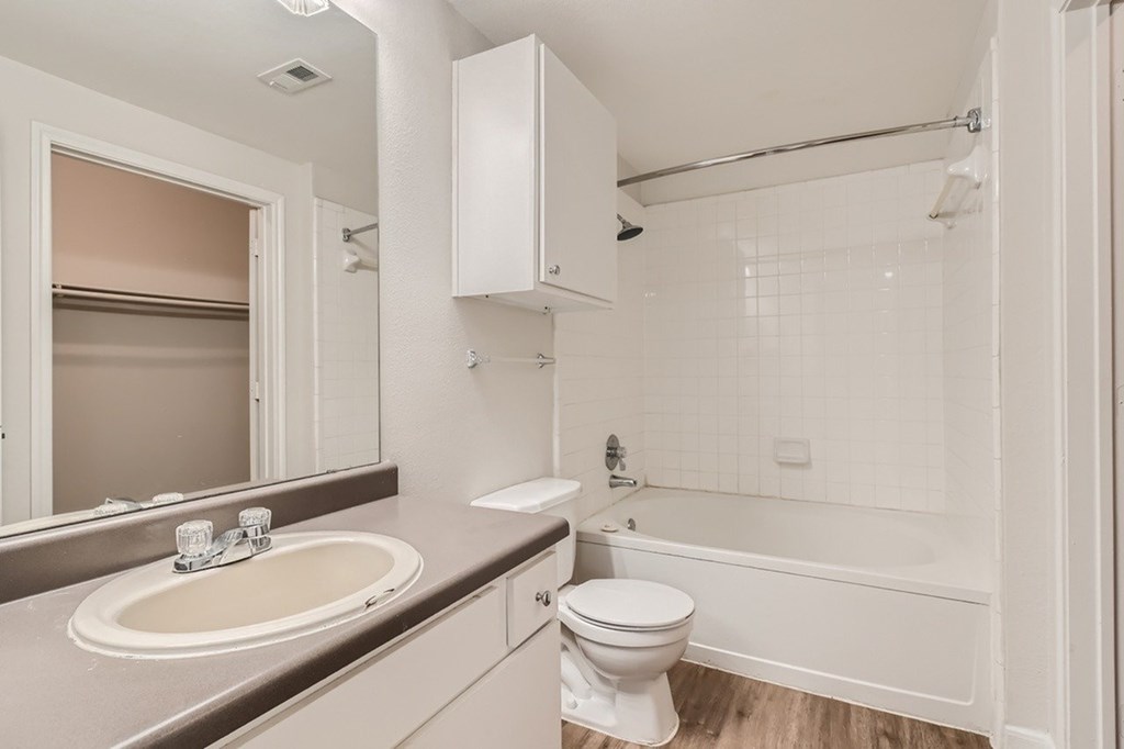 A white toilet sits next to a sink in a bathroom.