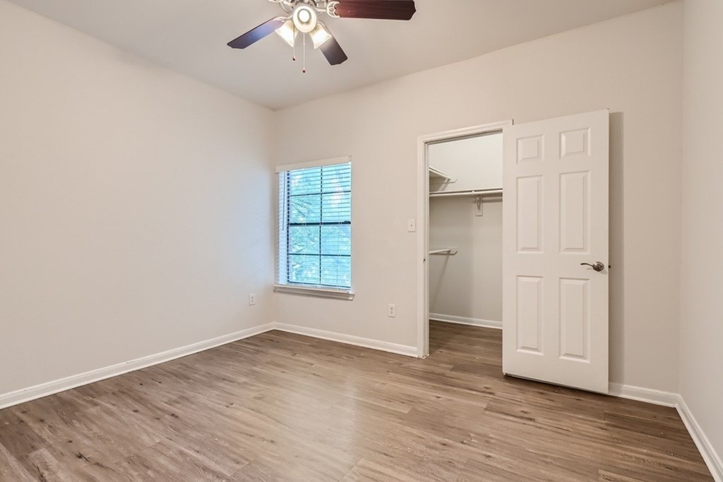 A room with a white door and a window with blinds.
