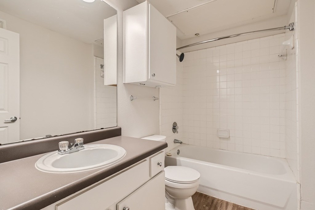 A white bathroom with a sink, toilet, and bathtub.