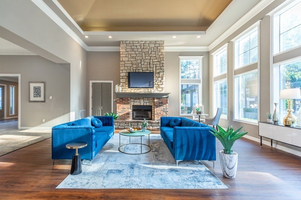 A living room with a blue couch and a fireplace.