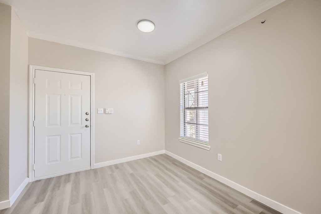 A room with a white door and a window with blinds.