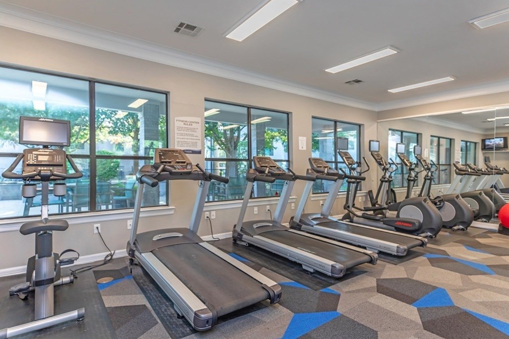 A gym with treadmills, exercise bikes, and elliptical machines.