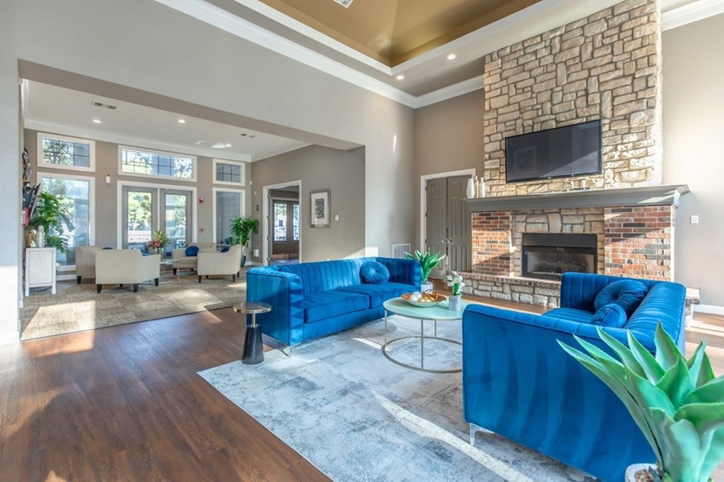 A living room with a blue couch and a fireplace.