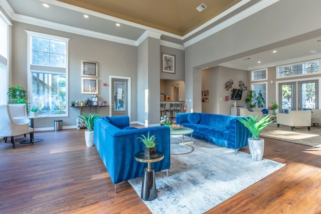 A living room with blue couches and wooden floors.