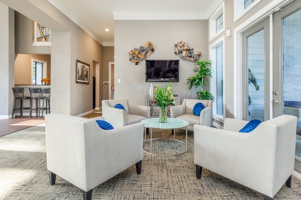 A living room with a white sofa and a glass coffee table.