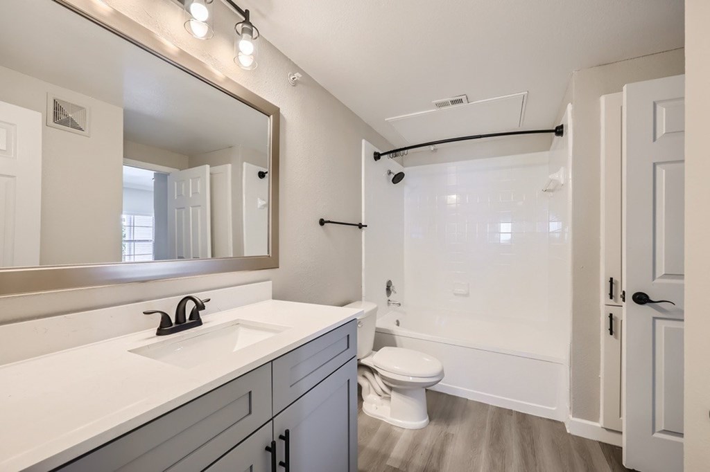 A white bathroom with a sink, toilet, and bathtub.