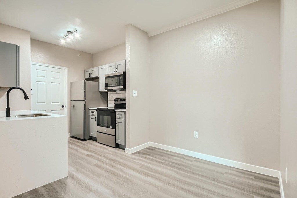 A kitchen with a white counter and stainless steel appliances.