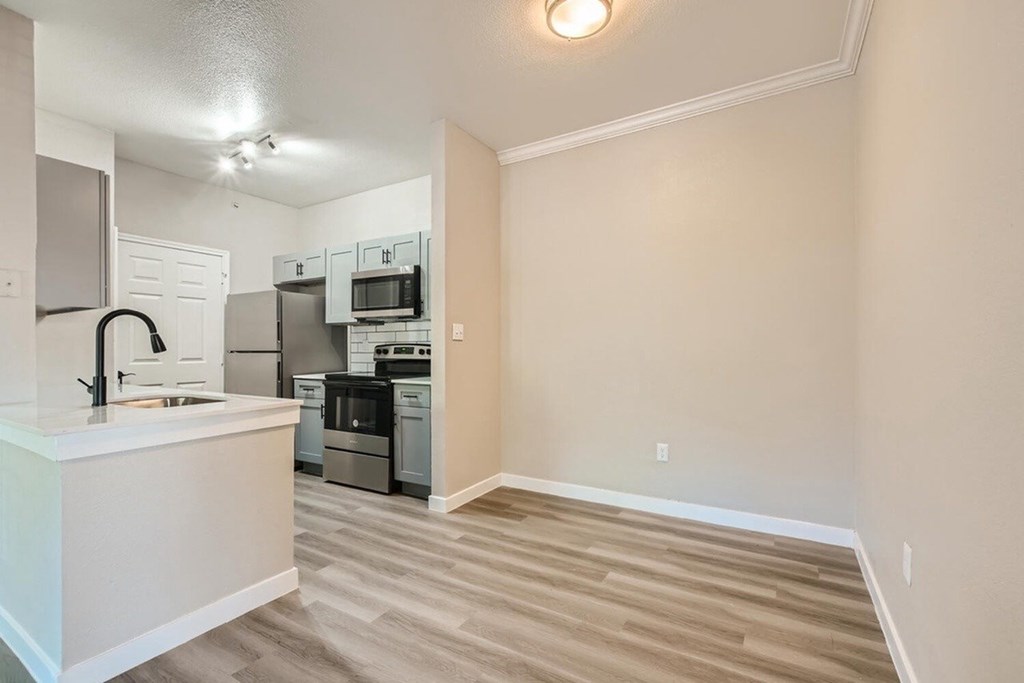 A kitchen with white cabinets and a white island with a sink.