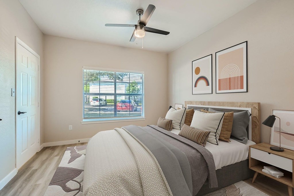 A bedroom with a large bed and a ceiling fan.
