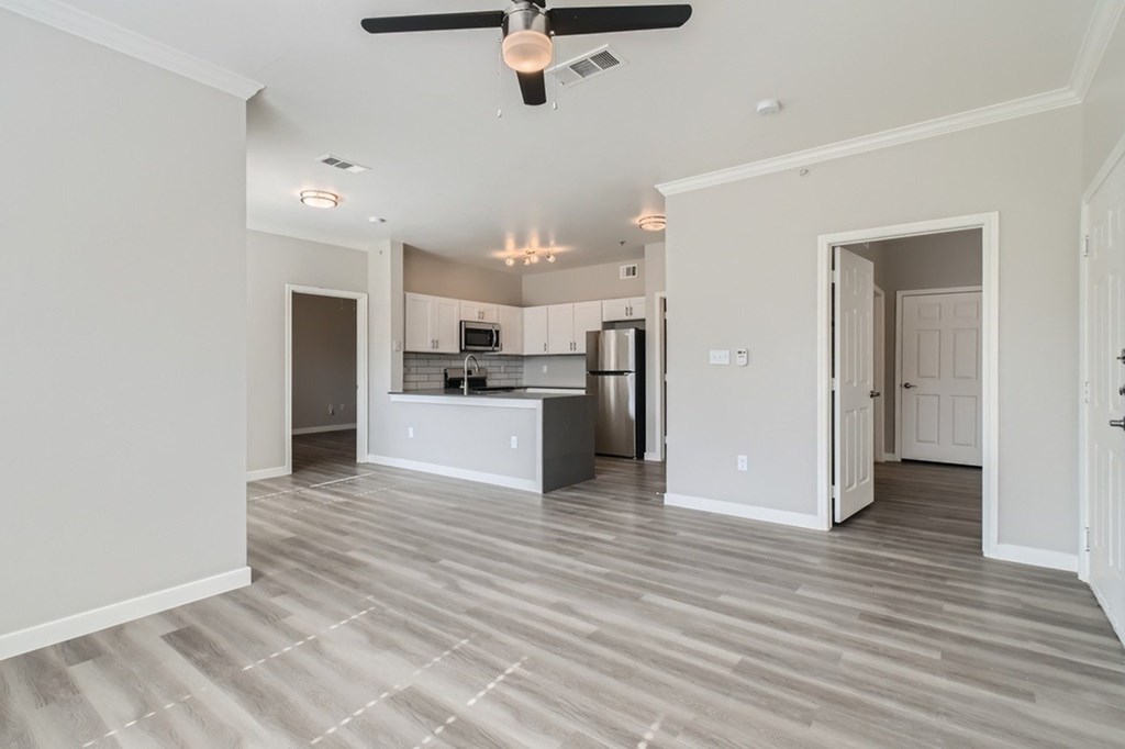 A spacious kitchen with a ceiling fan and lighting fixtures.