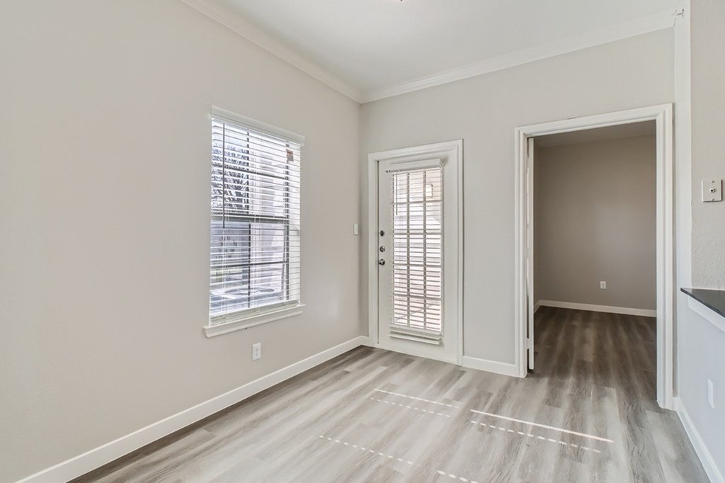 A room with a window, a door, and a wall socket.