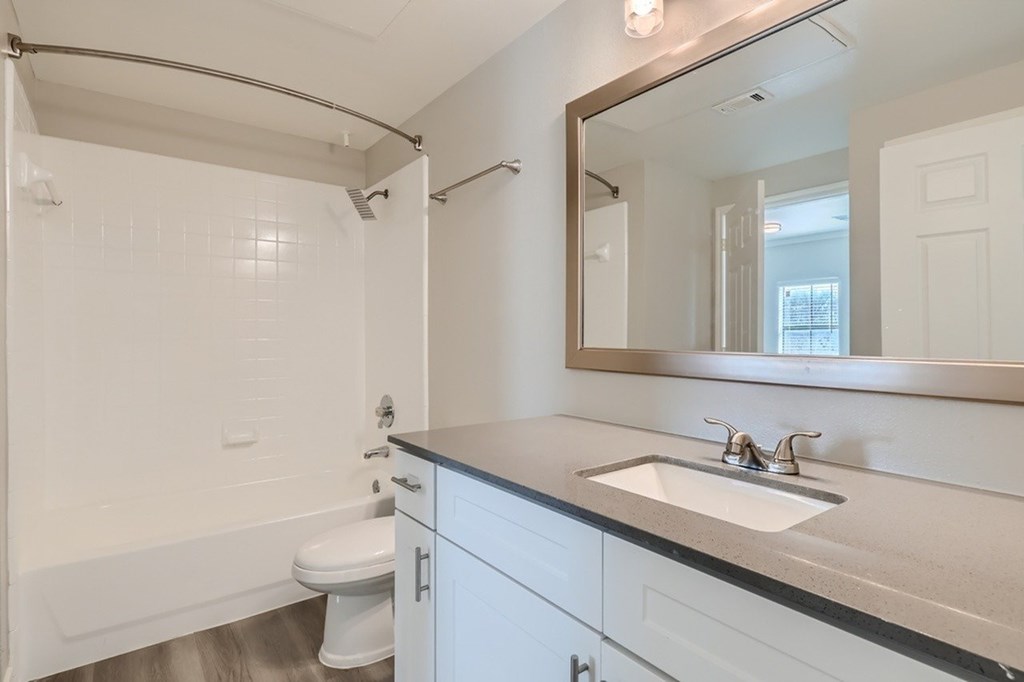 A white bathroom with a sink, toilet, and bathtub.