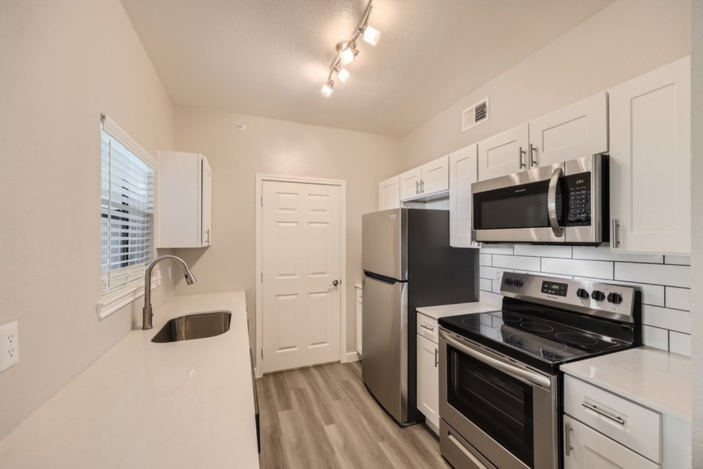 A kitchen with white cabinets and stainless steel appliances.