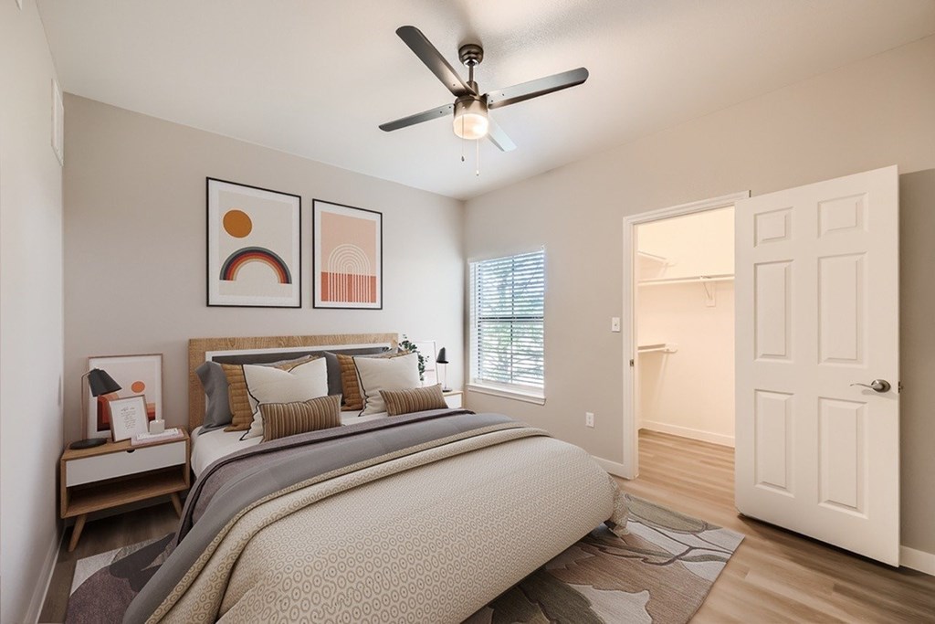 A bedroom with a large bed and a ceiling fan.