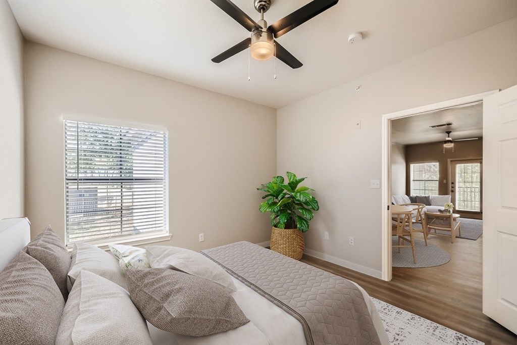 A bedroom with a large bed and a ceiling fan.