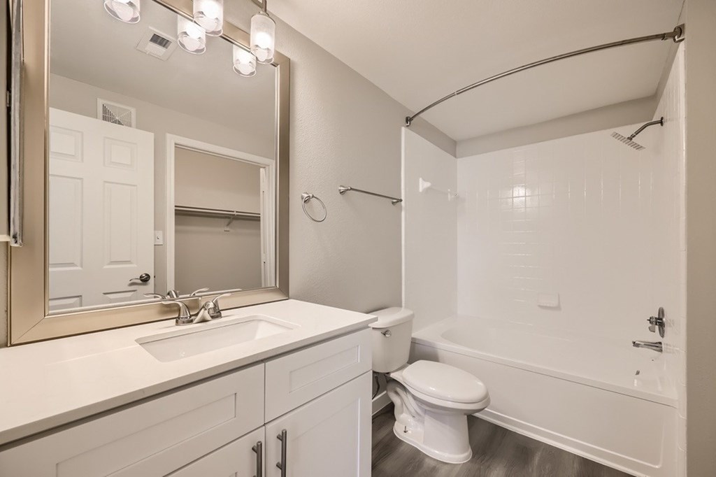 A white bathroom with a toilet, sink, and bathtub.