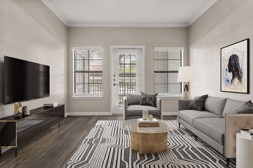 A living room with a grey couch, a coffee table, and a television.