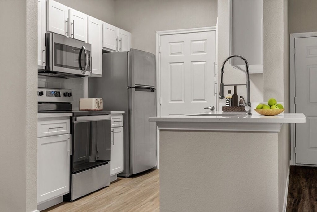 A kitchen with white appliances and cabinets.