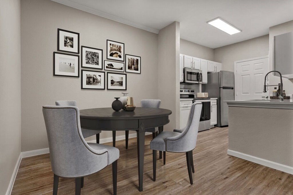 A dining room with a table and chairs and pictures on the wall.