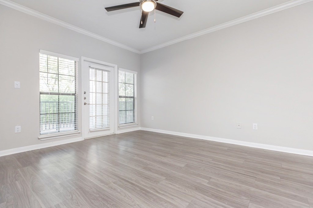 A room with a ceiling fan and a sliding glass door.