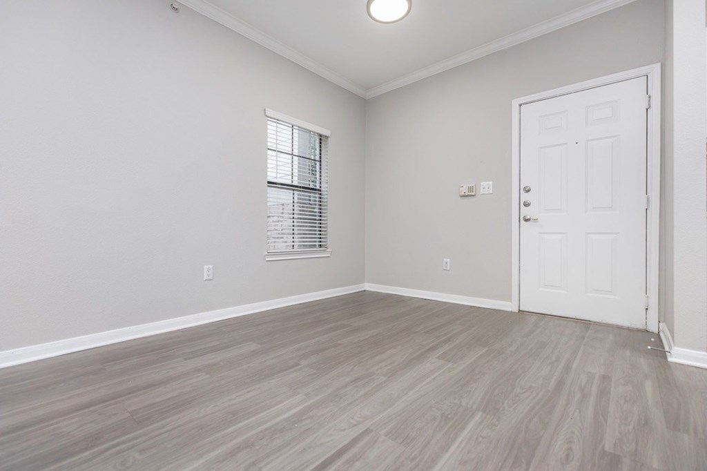 A room with a white door and a window with blinds.