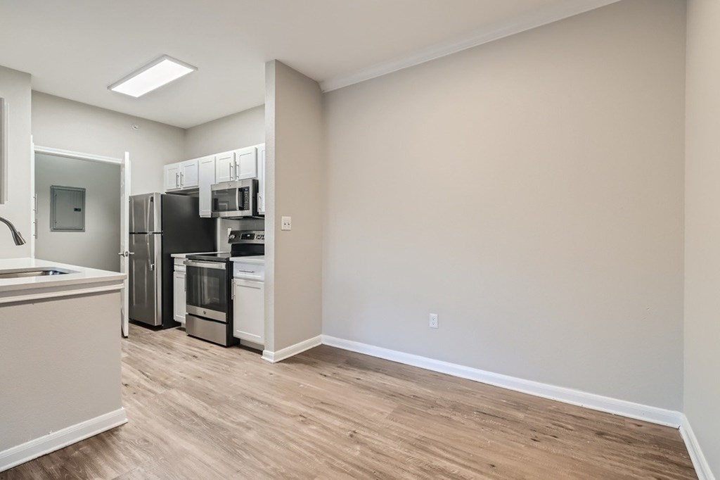 A kitchen with a refrigerator, oven, and microwave.