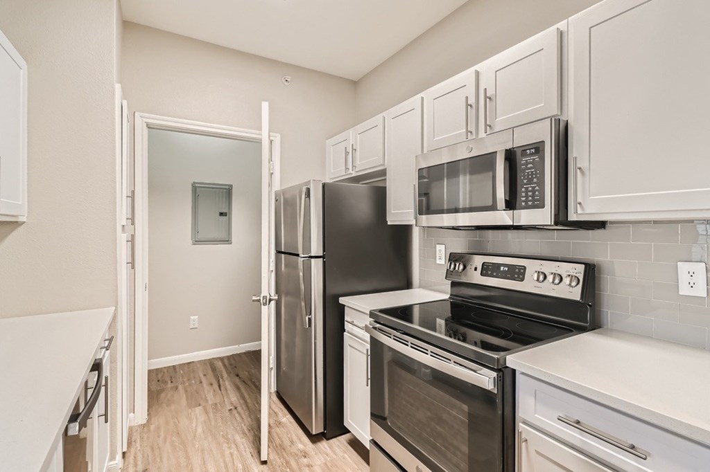 A kitchen with white cabinets and stainless steel appliances.