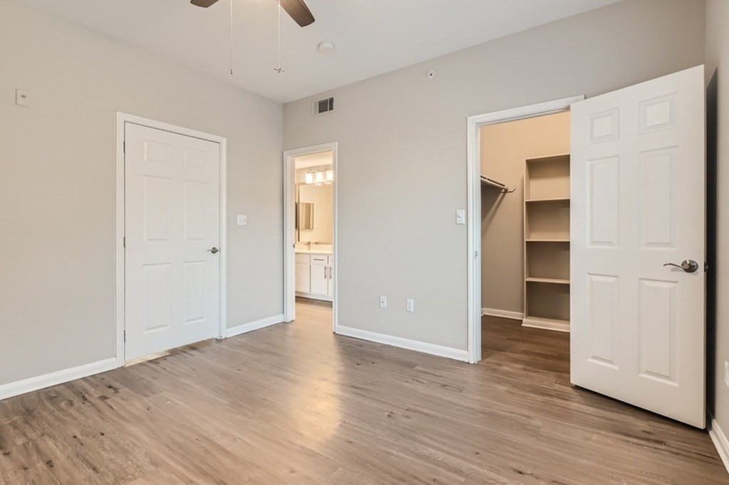 A room with white doors and wooden floors.