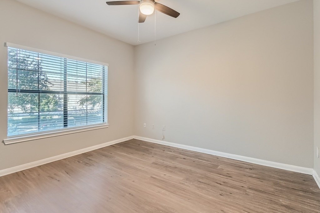 A room with a window and a ceiling fan.