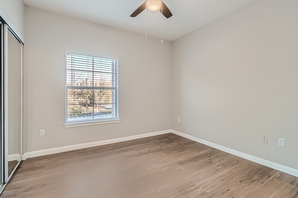 A room with a window and a ceiling fan.