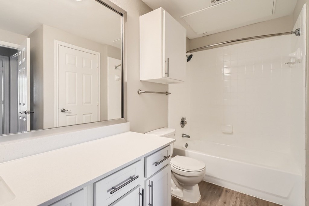 A white bathroom with a toilet, sink, and bathtub.