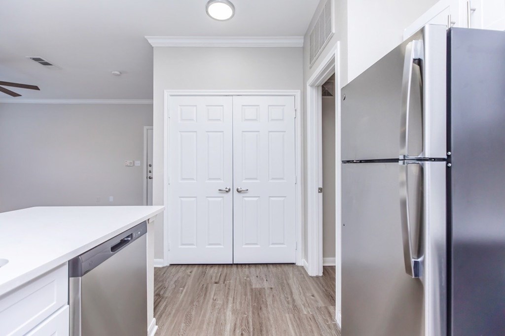 A kitchen with a white door and a white fridge.