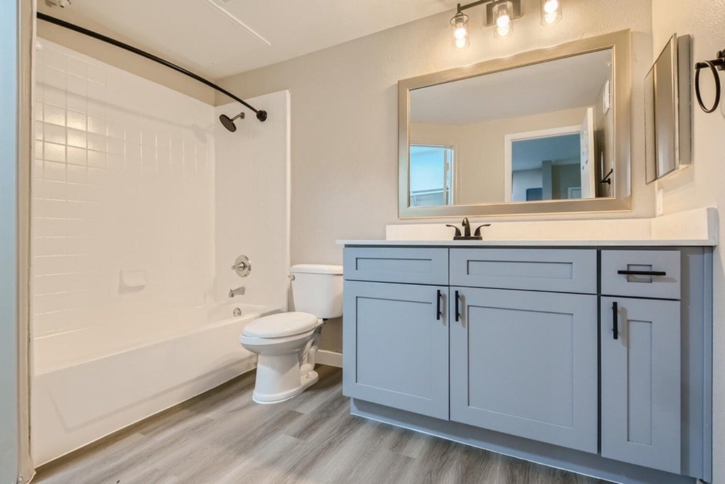 A bathroom with a toilet, sink, and bathtub.