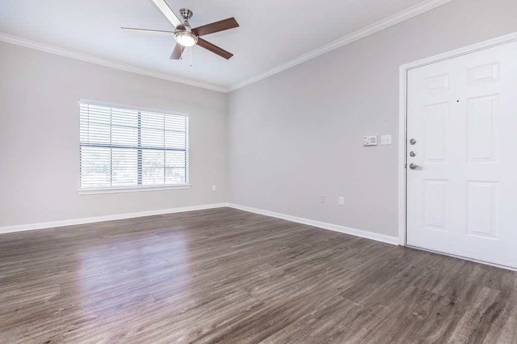 A room with a ceiling fan and a door.