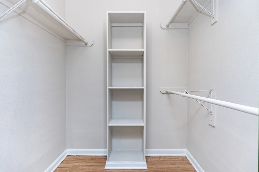 A white shelving unit in a room with white walls.