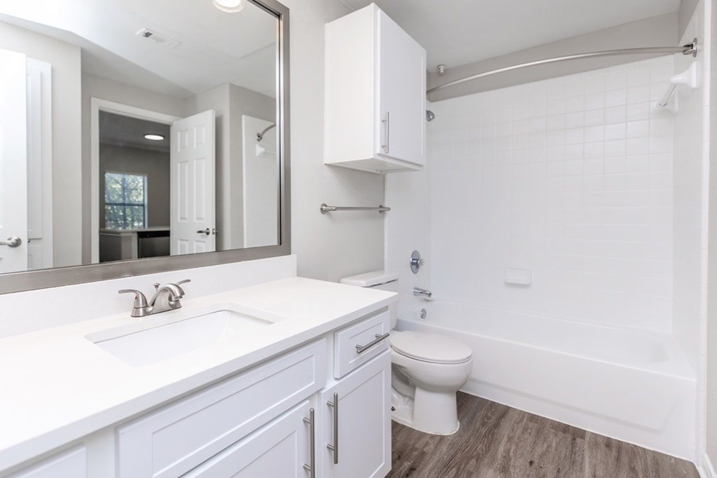 A white bathroom with a sink, toilet, and bathtub.