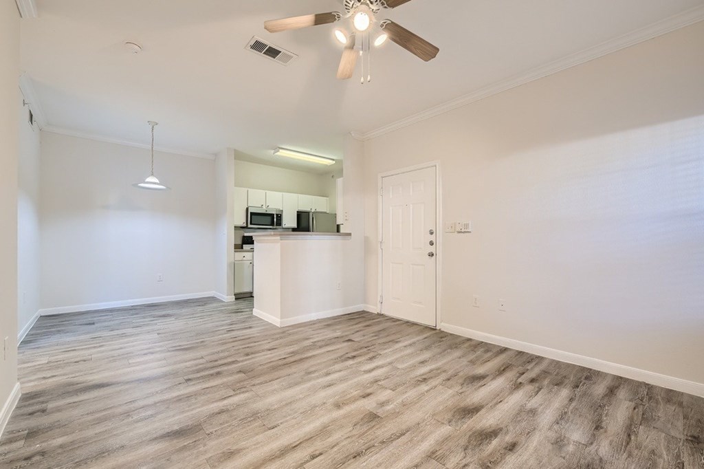 A room with a ceiling fan and a cabinet with a microwave.