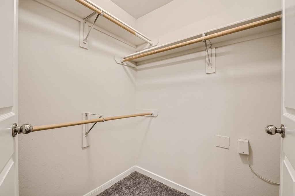 A white bathroom with a towel bar and a towel rack.