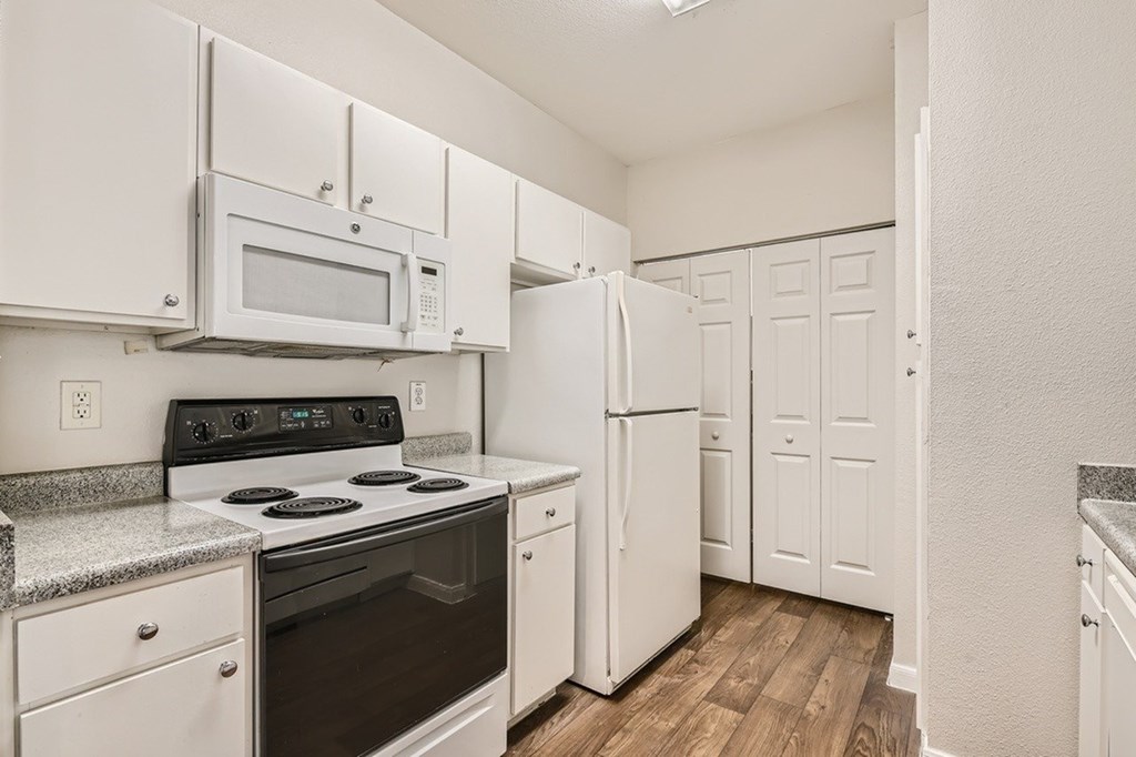 A kitchen with white appliances and cabinets.