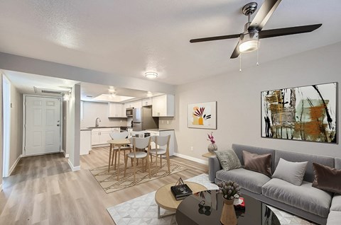 A living room with a grey couch, a coffee table, and a painting on the wall.