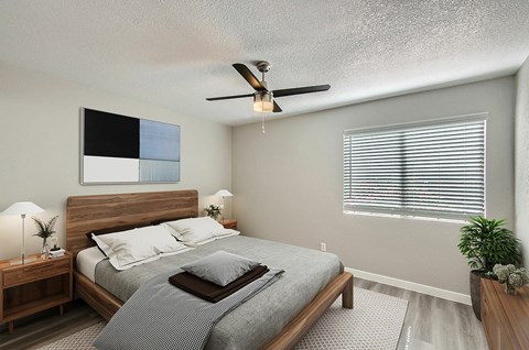 A bedroom with a bed, nightstand, and a ceiling fan.